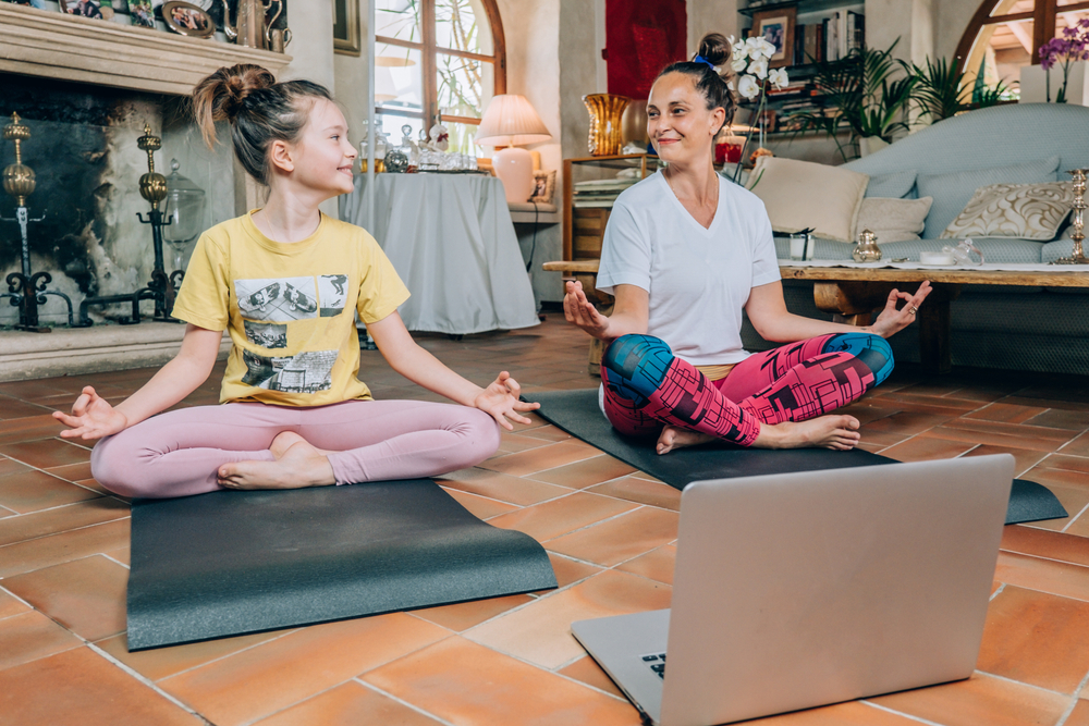mother and daughter enjoying online yoga class